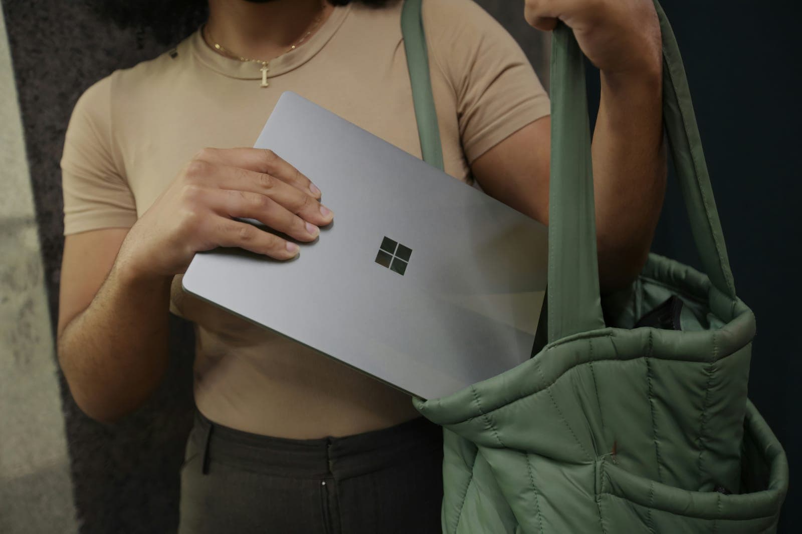 Persoon draagt een Surface-laptop onder de arm